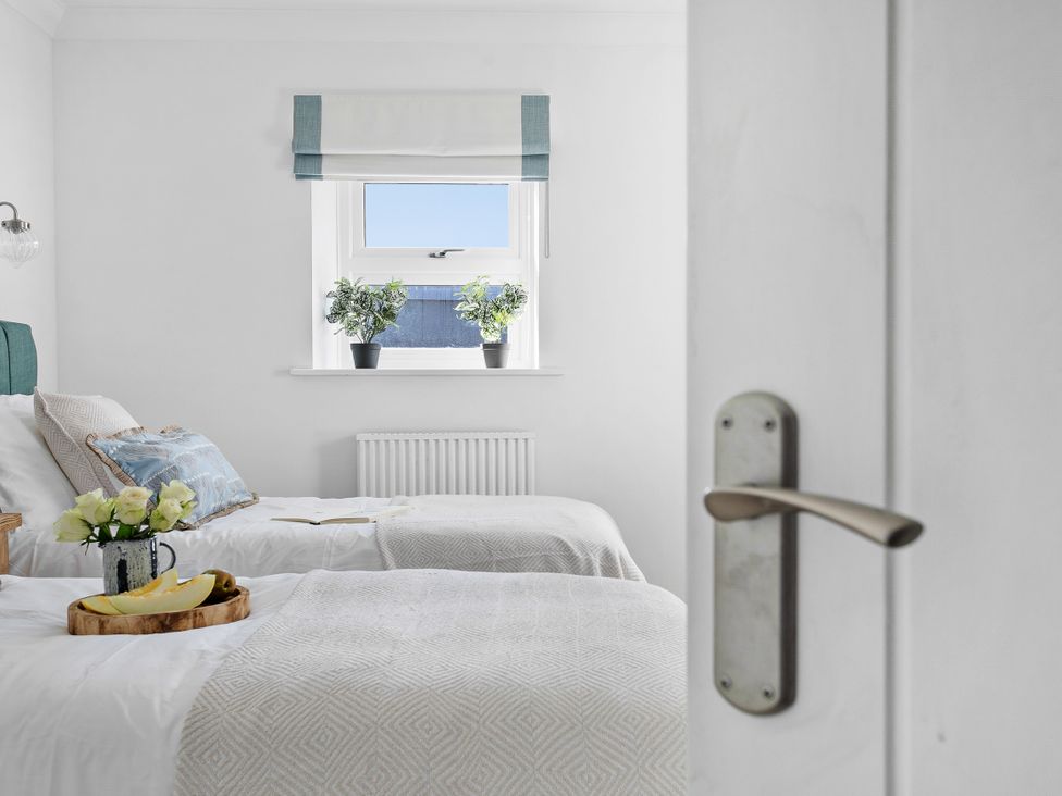 A bedroom with two beds and a window at The Renior Sea View Suite in Torquay