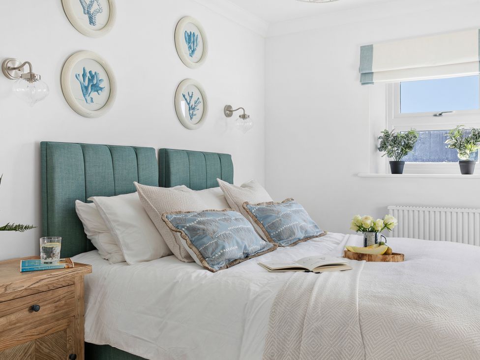 A bedroom with a bed and wall art at The Renior Sea View Suite in Torquay