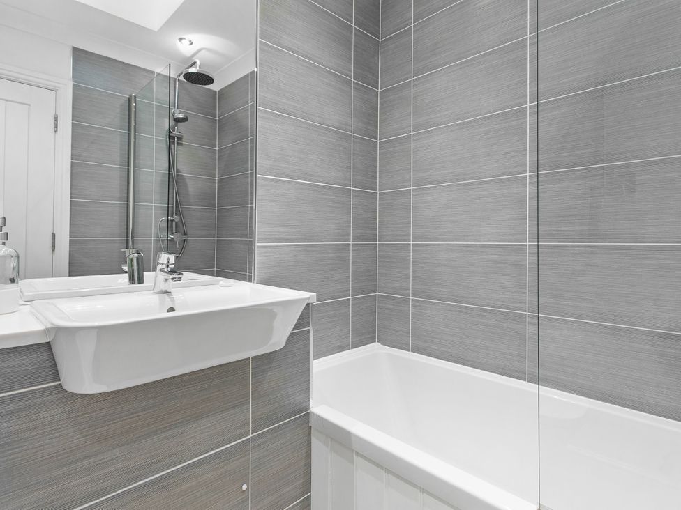 A bathroom with a bathtub and sink at The Renior Sea View Suite in Torquay