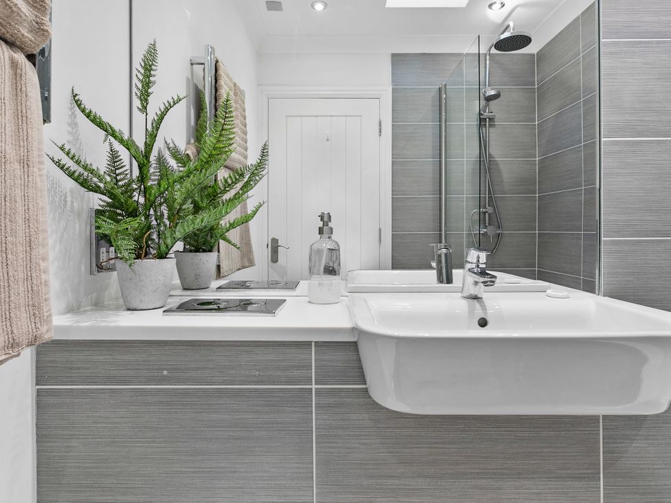 A bathroom with a sink and shower at The Renior Sea View Suite in Torquay