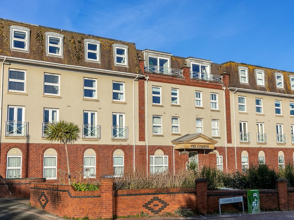 A building with balconies and an entrance sign at The Cobyn in Torquay