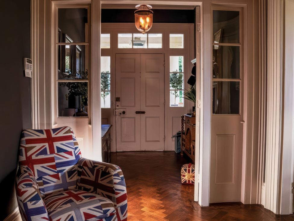 A hallway with an armchair and a door at St Anne's Manor in Torquay