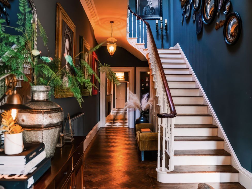 A hallway with a staircase and framed pictures at St Anne's Manor in Torquay