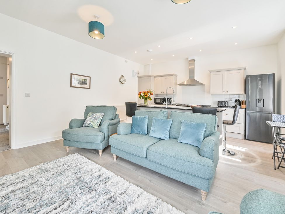 A living room with a kitchen and sofa at The Falstone Apartment in Torquay