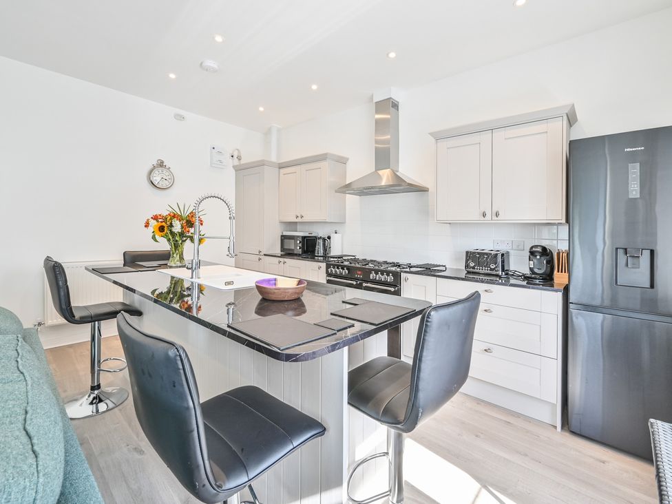 A kitchen with appliances and an island at The Falstone Apartment in Torquay