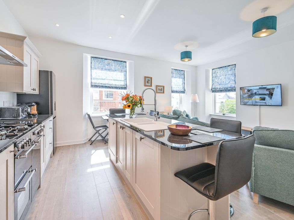 A kitchen with a stove and refrigerator at The Falstone Apartment in Torquay