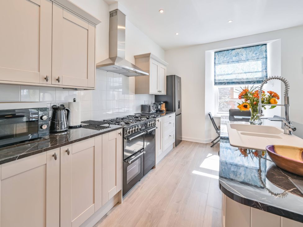A kitchen with various appliances and a sink at The Falstone Apartment in Torquay