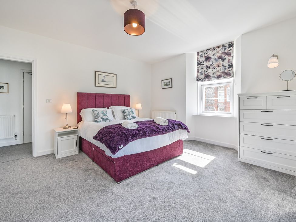 A bedroom with a bed and dressers at The Falstone Apartment in Torquay