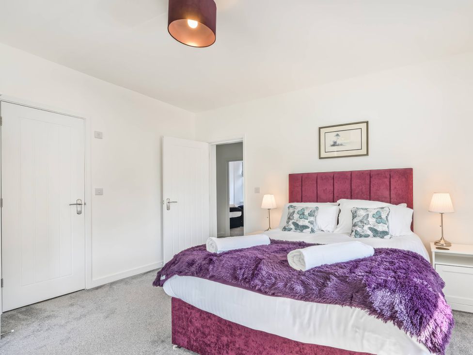 A bedroom with a bed and nightstands at The Falstone Apartment in Torquay
