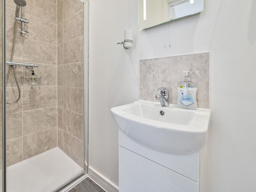 A bathroom with a shower and sink at The Falstone Apartment in Torquay
