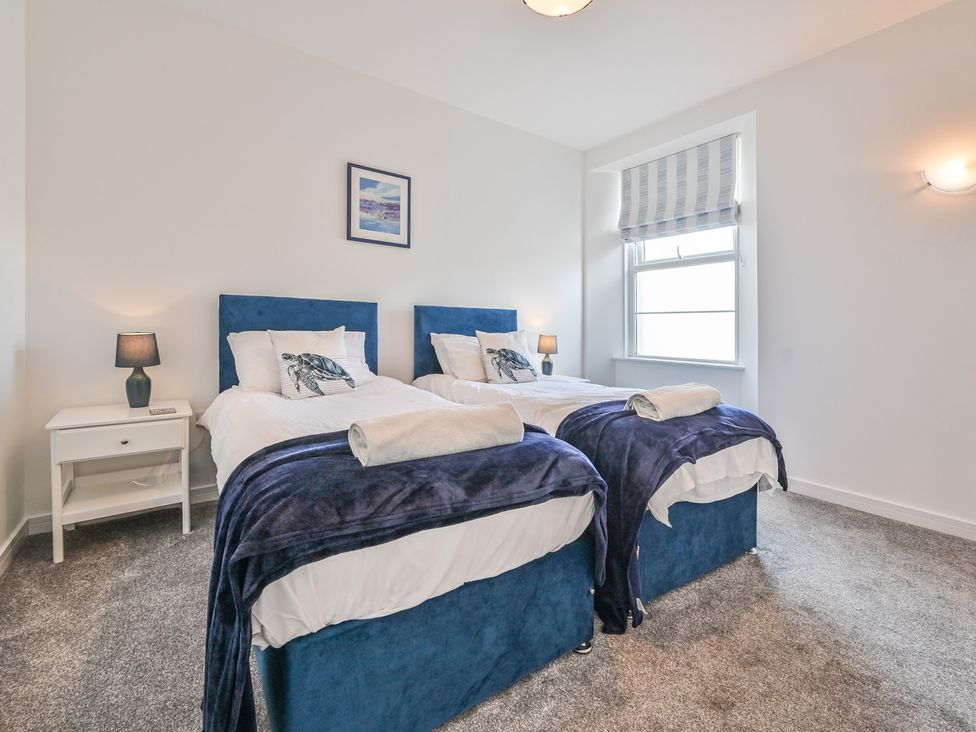 A bedroom with two twin beds and a bedside table at The Falstone Apartment in Torquay