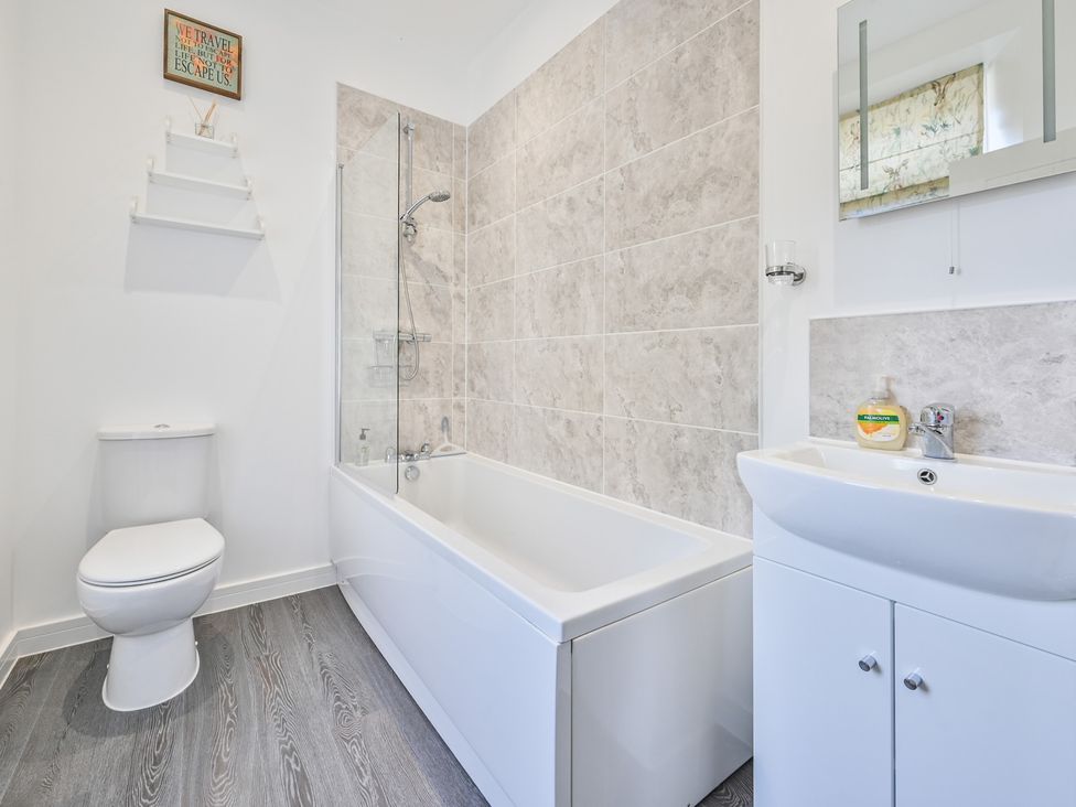 A bathroom with a bathtub, toilet, sink, and shower at The Falstone Apartment in Torquay