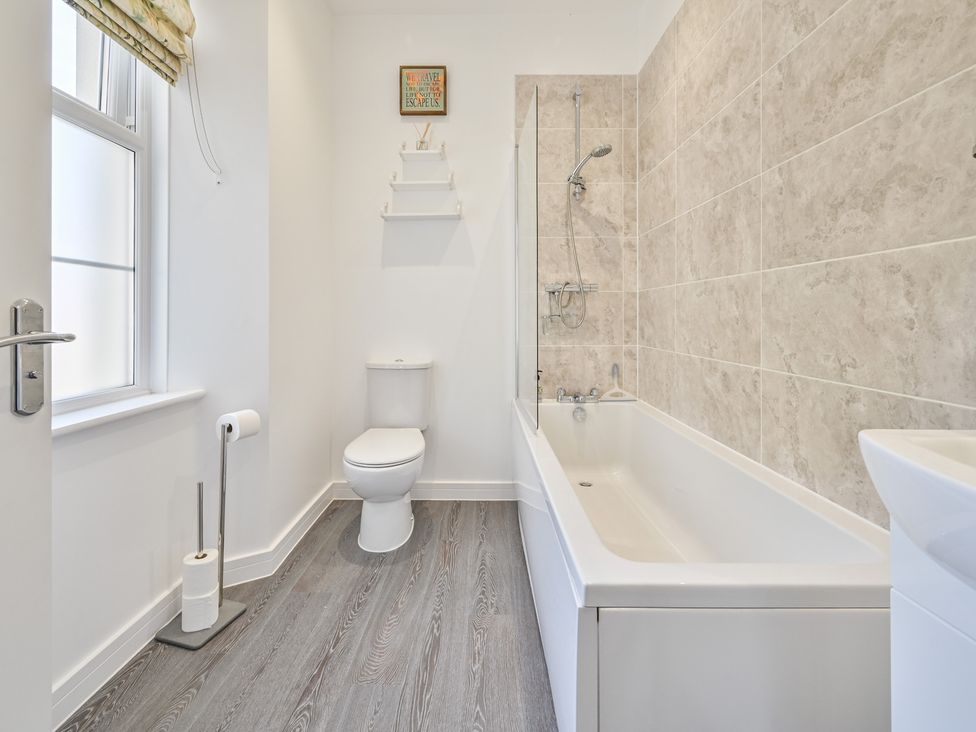 A bathroom with a bathtub and toilet at The Falstone Apartment in Torquay