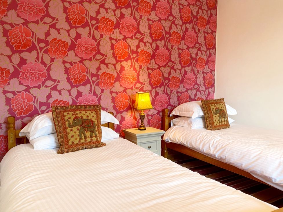 A bedroom with two beds and a lamp at Upper Stable - The Stables Apartments at Meadfoot Bay Torquay