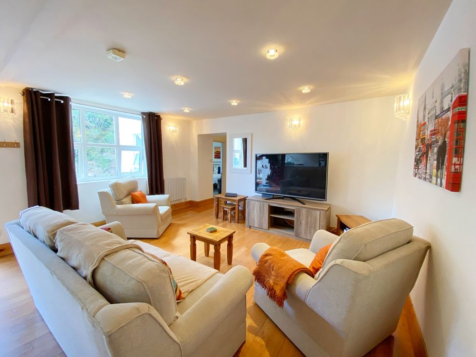 A living room with a TV and seating at Lower Stable - The Stables Apartments at Meadfoot Bay, Torquay