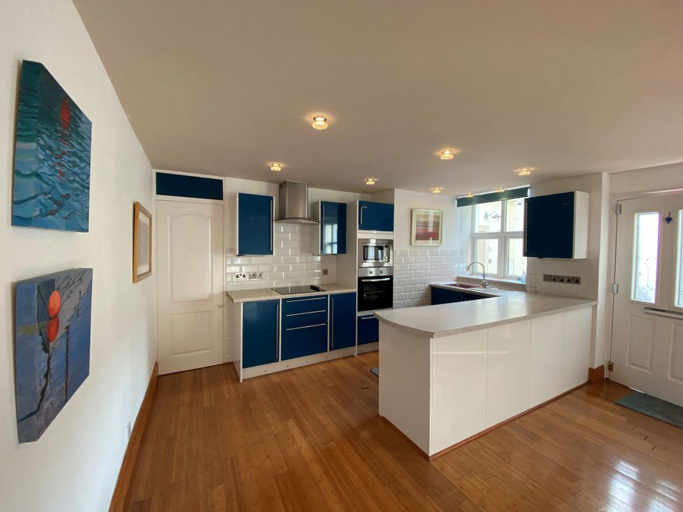 A kitchen with blue cabinets and white countertops at Lower Stable - The Stables Apartments at Meadfoot Bay, Torquay