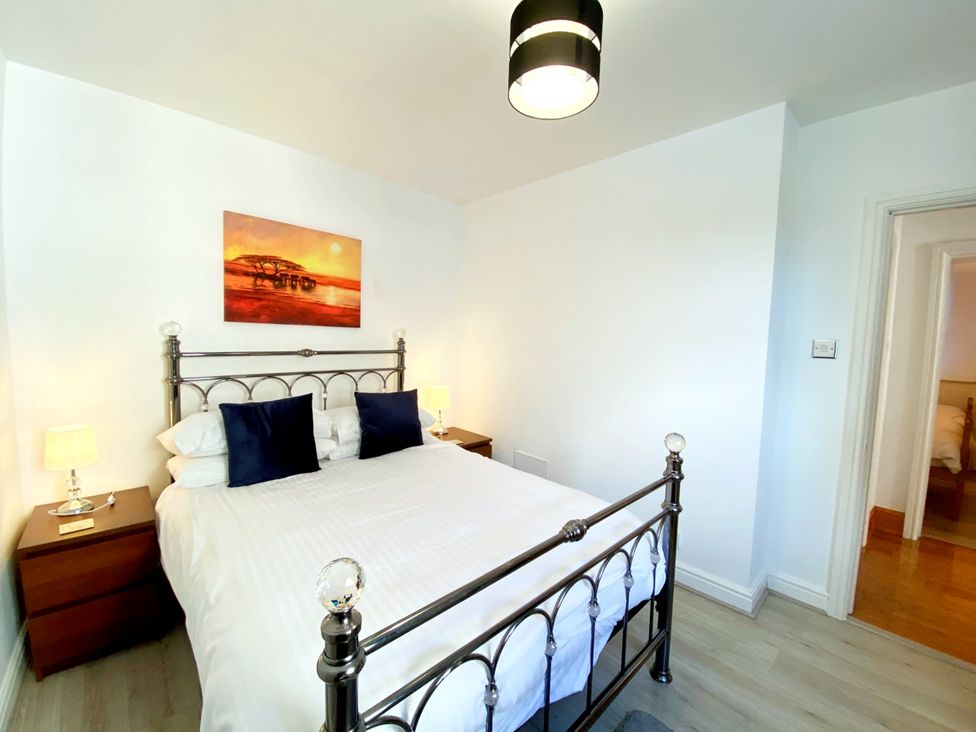 A bedroom with a bed and nightstands at Lower Stable - The Stables Apartments at Meadfoot Bay, Torquay