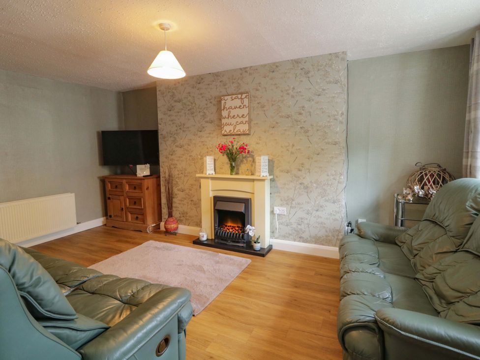 A living room with a fireplace and a television at 4 Bed Property in Northern Ireland Garrison, County Fermanagh