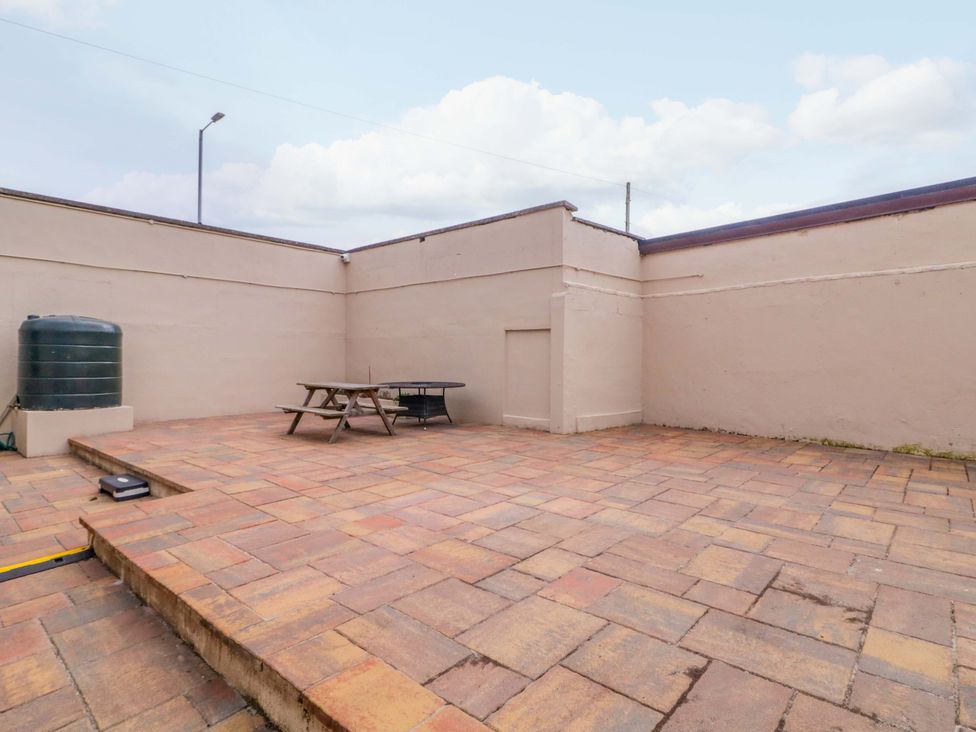A patio area with a table and an outdoor water tank at 4 Bed Property in Northern Ireland Garrison, County Fermanagh