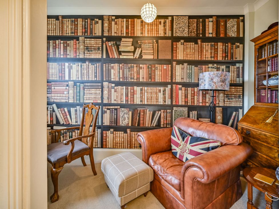 A reading room with a bookshelf and leather chairs at Muntham Luxury Town House with Hot Tub in Torquay