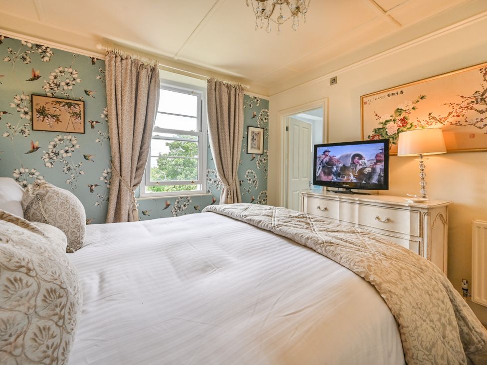 A bedroom with a bed and a television at Muntham Luxury Town House with Hot Tub Torquay