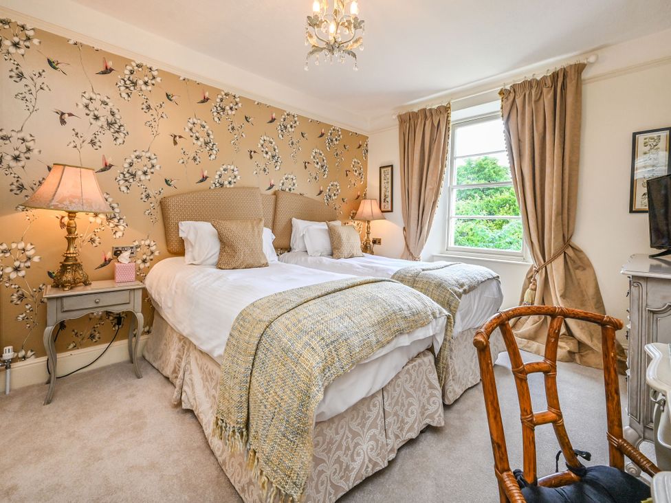 A bedroom with two beds and a chair at Muntham Luxury Town House with Hot Tub in Torquay