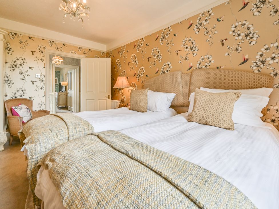 A bedroom with beds and a chair at Muntham Luxury Town House with Hot Tub in Torquay