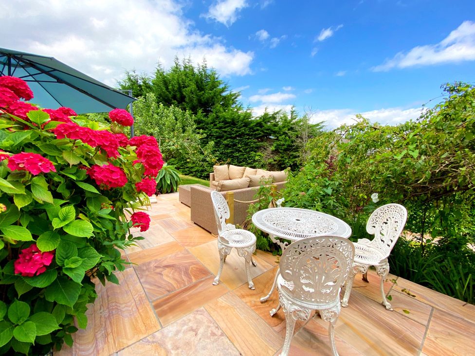 A garden with outdoor seating and flowers at Muntham Luxury Town House with Hot Tub in Torquay