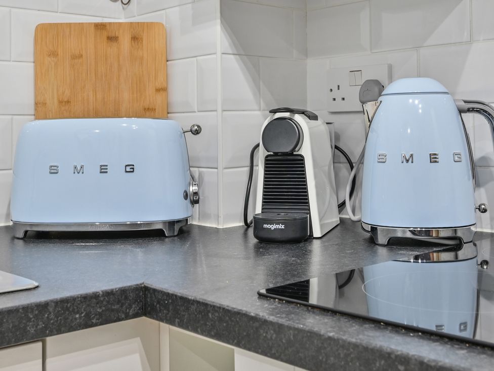 A kitchen with a toaster, kettle, coffee machine, and chopping board at Muntham Deluxe Apartment 2 in Torquay