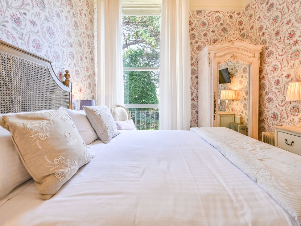 A bedroom with a bed and curtains at Muntham Deluxe Apartment 2, Torquay