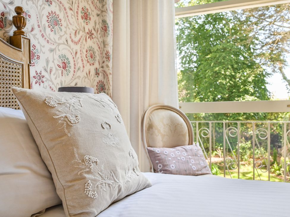 A bedroom with a bed and pillows at Muntham Deluxe Apartment 2 in Torquay