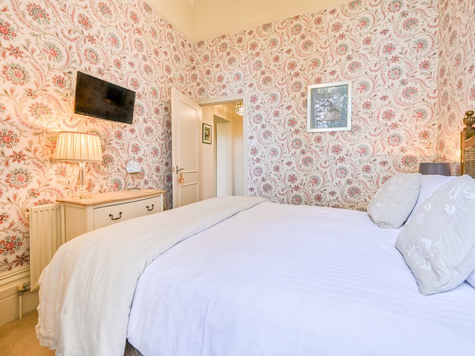 A bedroom with a bed and lamp at Muntham Deluxe Apartment 2 in Torquay