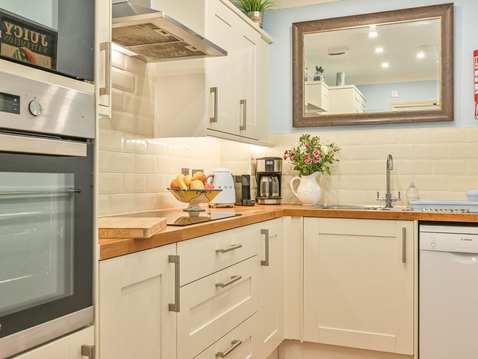 A kitchen with cabinets, sink, oven, and a coffee machine at Muntham Deluxe Apartment 3, Torquay
