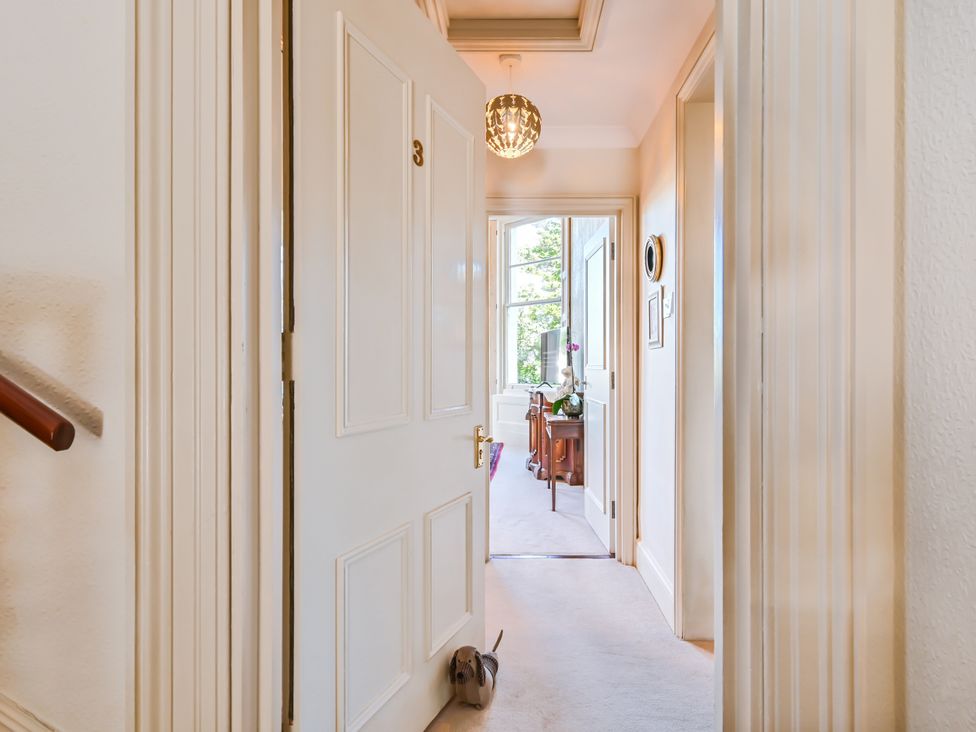 A hallway with a door and light fixture at Muntham Deluxe Apartment 3 in Torquay