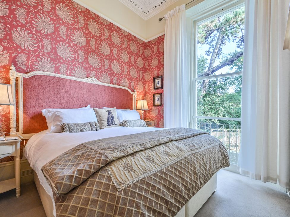 A bedroom with a bed and bedside table at Muntham Deluxe Apartment 3 in Torquay