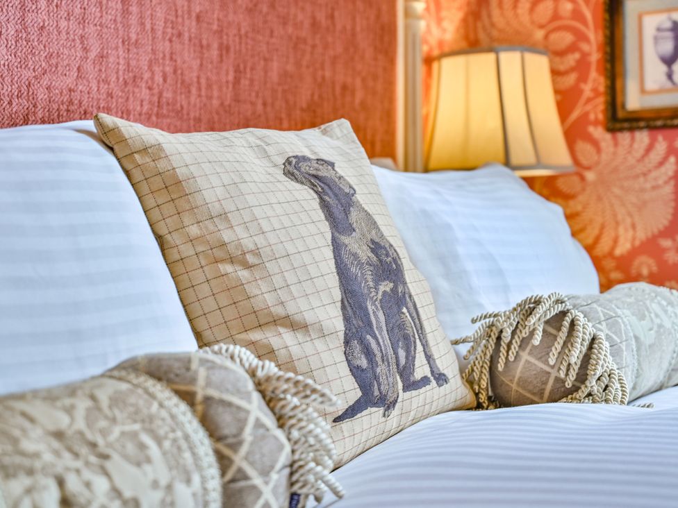 A sofa with decorative pillows and a lamp at Muntham Deluxe Apartment 3 in Torquay