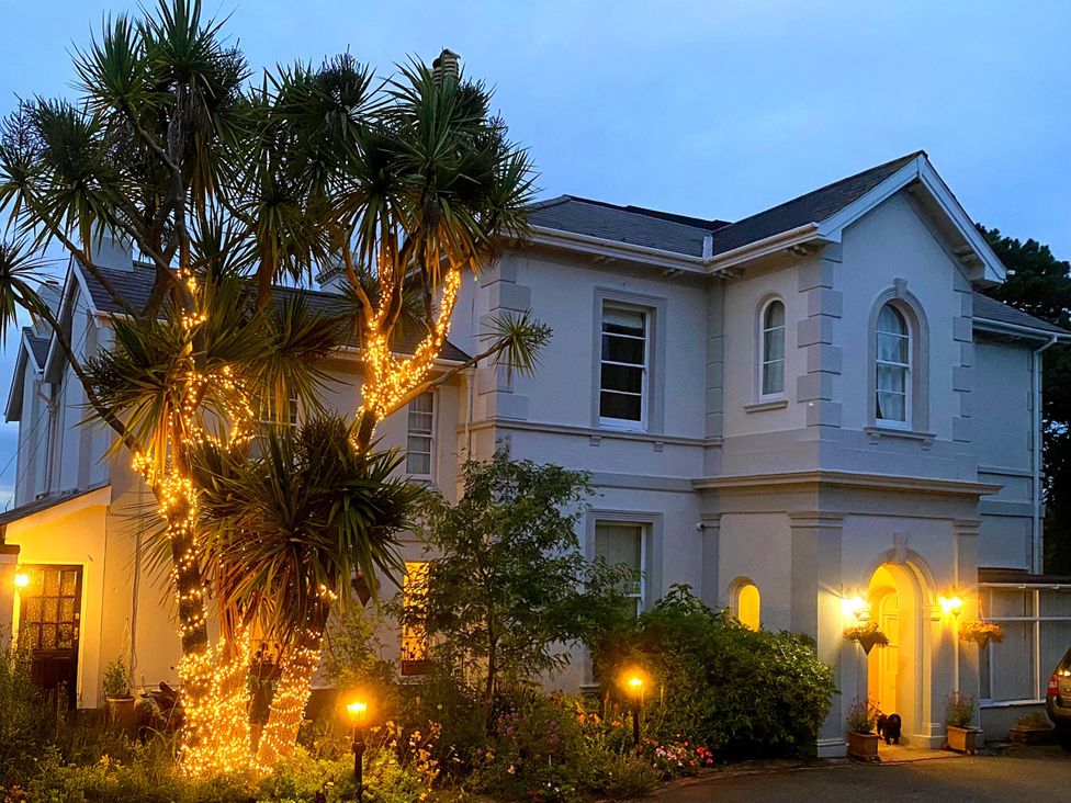 A house with palm trees and lights at Muntham Deluxe Apartment 3 in Torquay