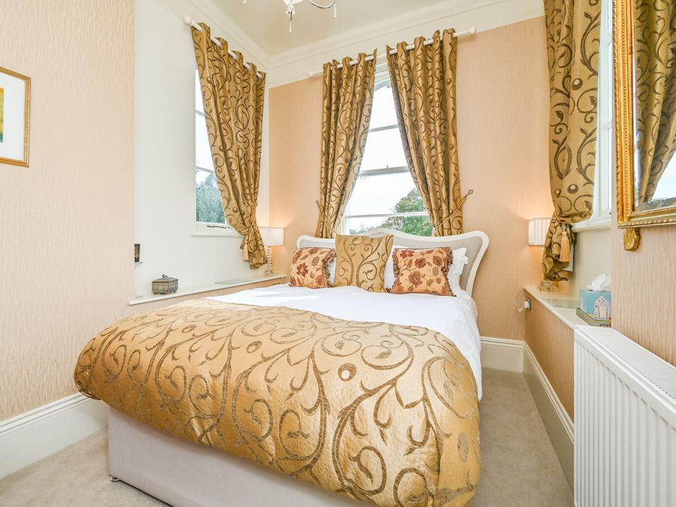 A bedroom with a bed and decorative cushions at Muntham Apartment 4 Torquay