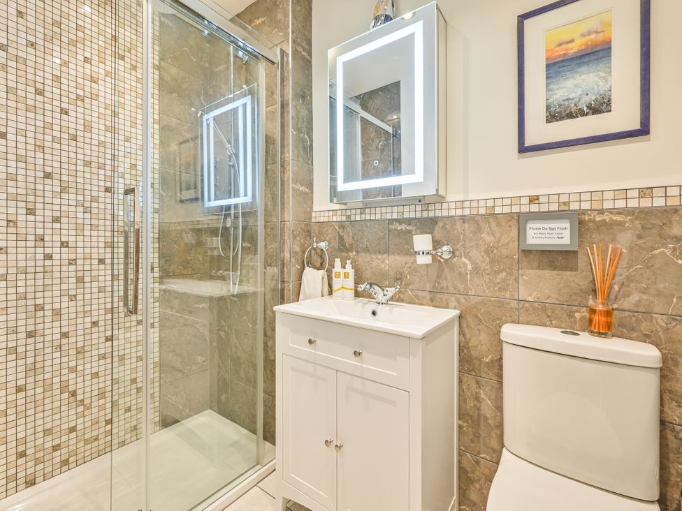 A bathroom with a shower, sink, and toilet at Muntham Apartment 4 in Torquay