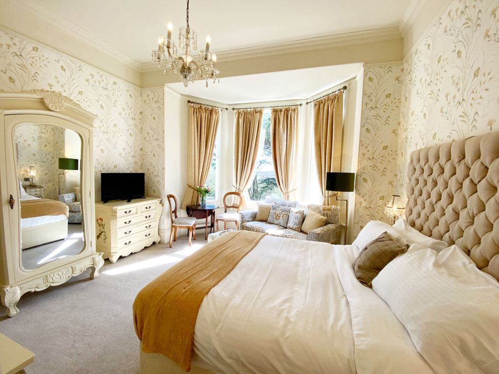 A bedroom with a bed and a mirror at Muntham Studio Apartment 5 in Torquay