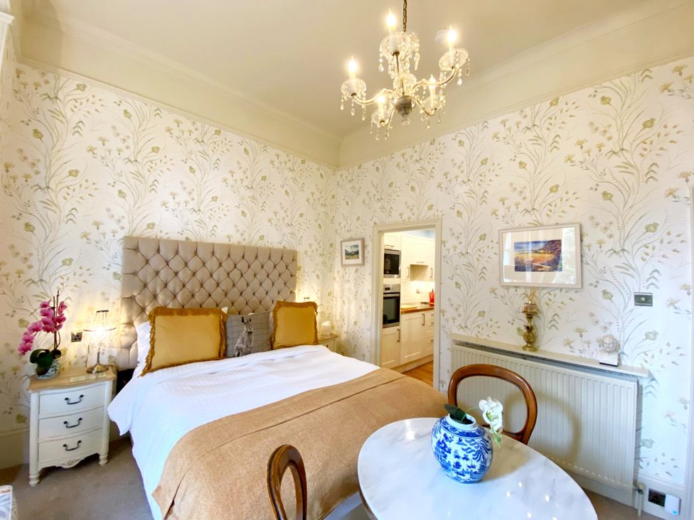 A bedroom with a bed and table at Muntham Studio Apartment 5 in Torquay