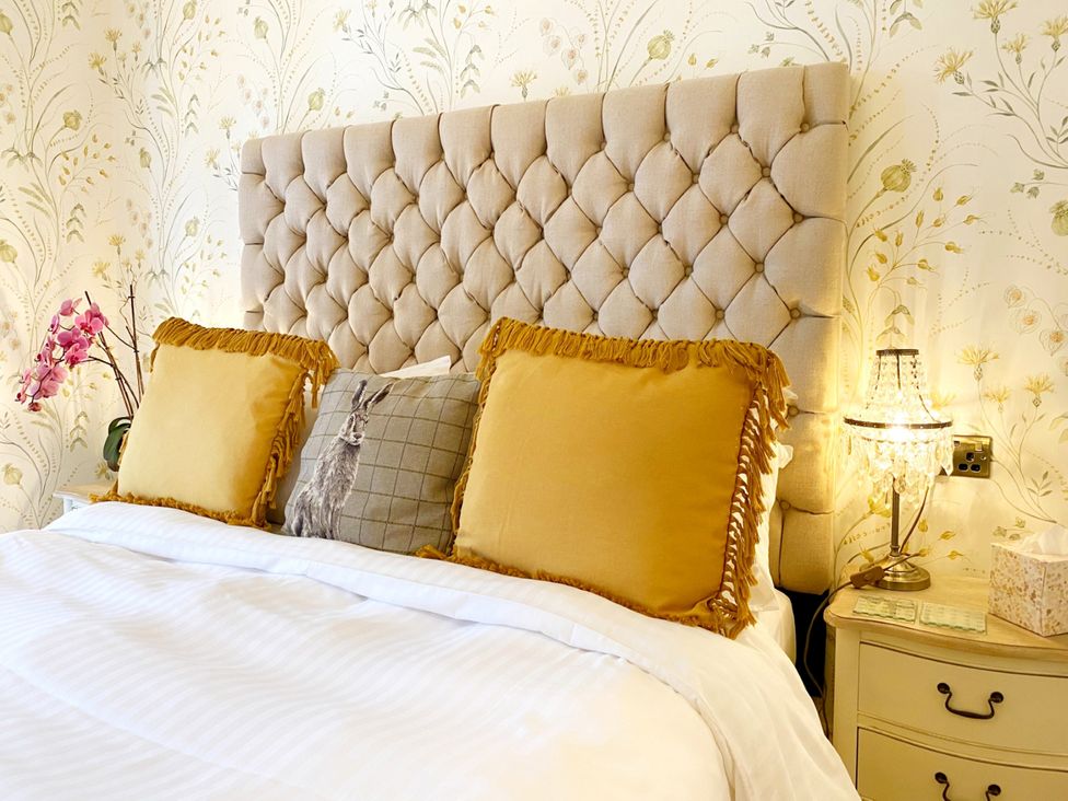 A bedroom with a beige headboard and pillows at Muntham Studio Apartment 5 Torquay