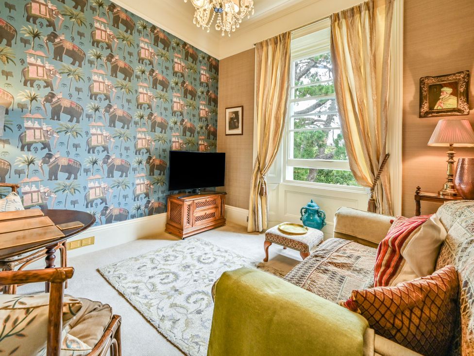 A living room with a television and seating area at Muntham Apartment 6 in Torquay