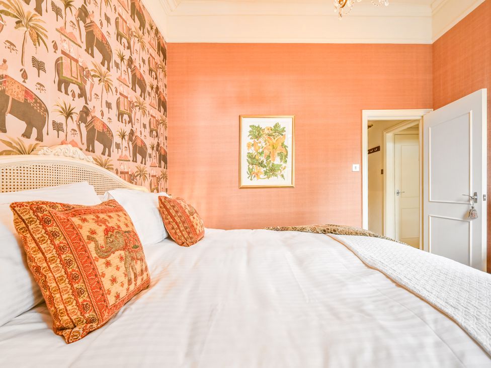 A bedroom with a bed and decorative wallpaper at Muntham Apartment 6 in Torquay