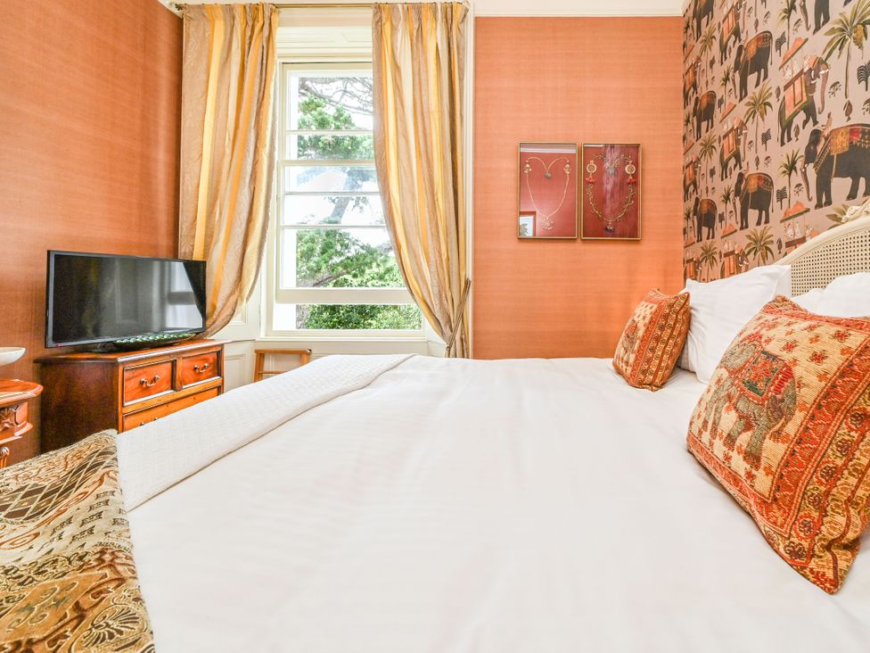 A bedroom with a bed and television at Muntham Apartment 6 in Torquay