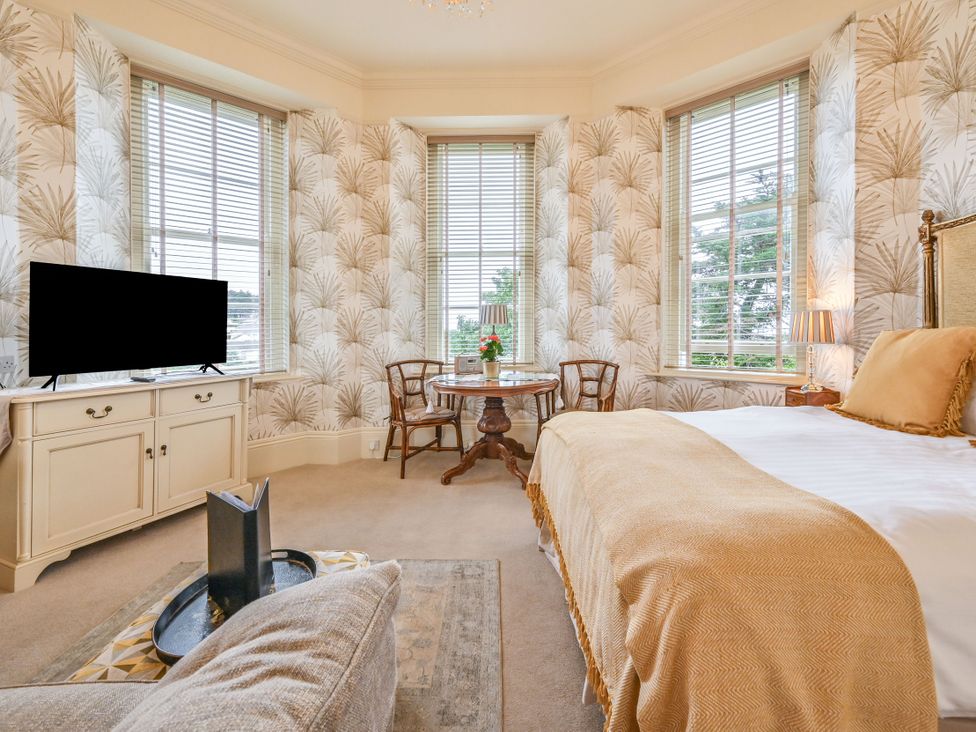 A bedroom with a bed and a table at Muntham - Studio Apartment 7 Torquay