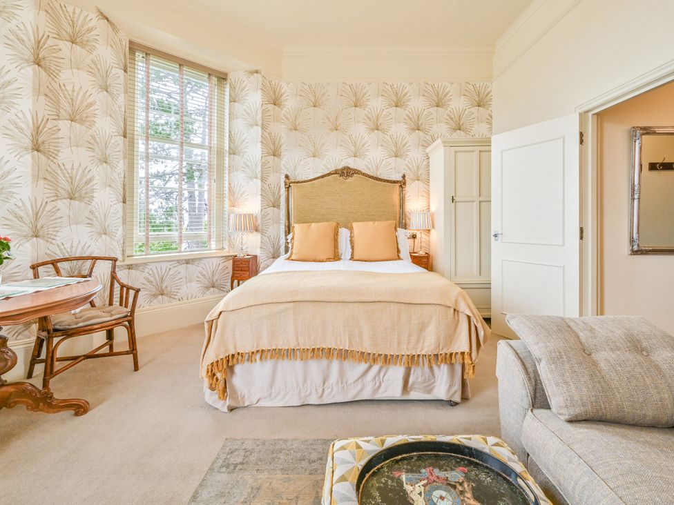 A bedroom with a bed and table at Muntham - Studio Apartment 7 in Torquay