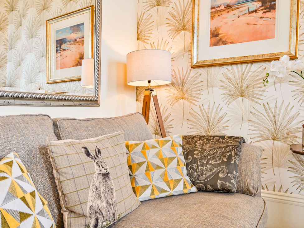 A living room with a sofa and cushions at Muntham - Studio Apartment 7 in Torquay
