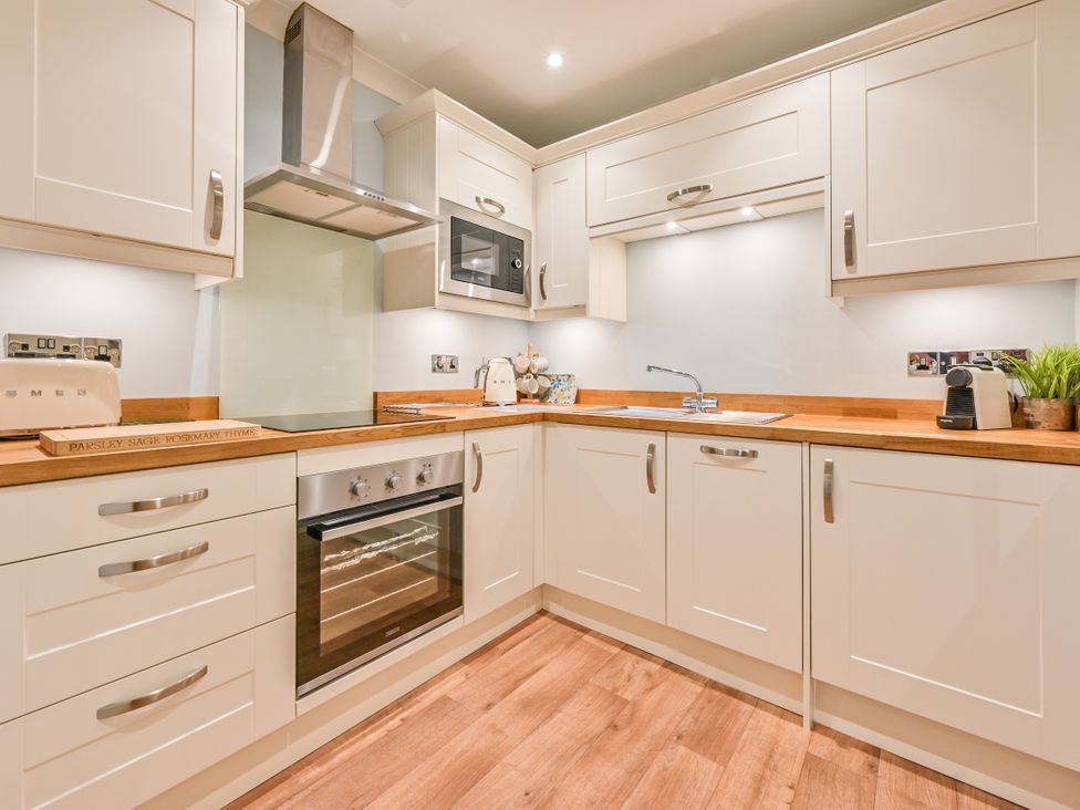 A kitchen with cabinets, oven, sink, and microwave at Muntham - Studio Apartment 7, Torquay