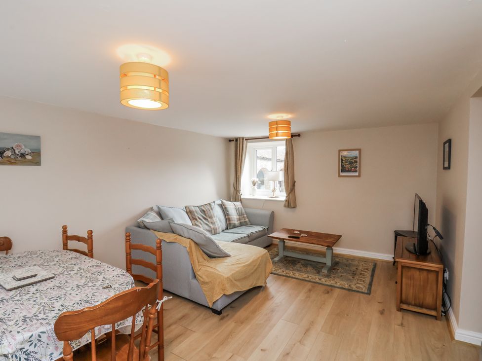 A living room with a sofa and dining table at Starlight Cottage in 
